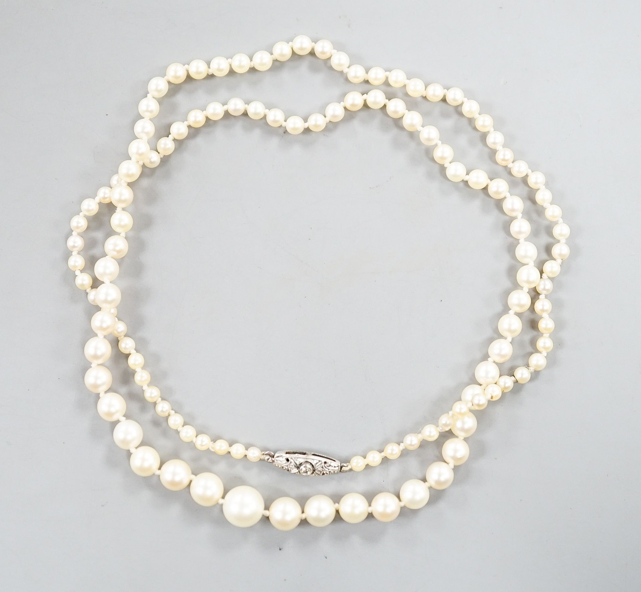 An early 20th century single strand graduated pearl necklace(not tested for natural or cultured), with diamond set white metal clasp, 49cm, largest pearl diameter 7.1mm, smallest 2.1mm, gross weight 10 grams.